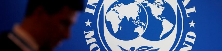 FILE PHOTO: A participant stands near a logo of IMF at the International Monetary Fund - World Bank Annual Meeting 2018 in Nusa Dua Townhall Meeting to Explain IMF Requested Reforms from Lebanon
